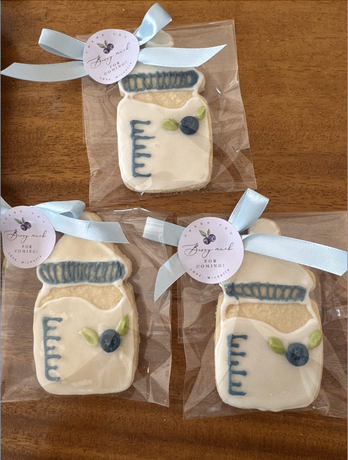 Mason jar cookies with blueberry detail and blue ribbon